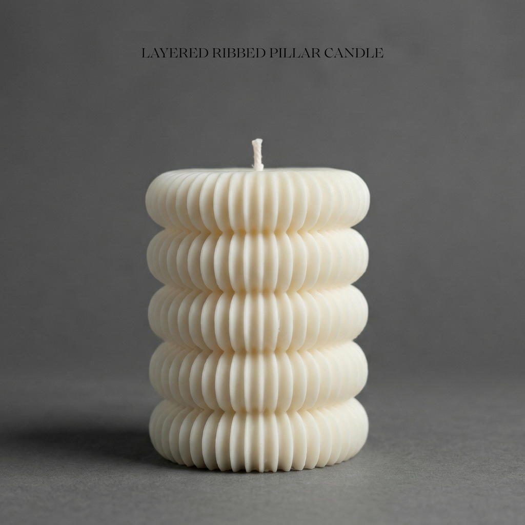White ribbed pillar candle on a gray background