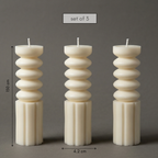 Set of three decorative candles with stacked design on a gray background