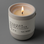 Candle in a white container labeled 'Saigon Heritage' on a gray background