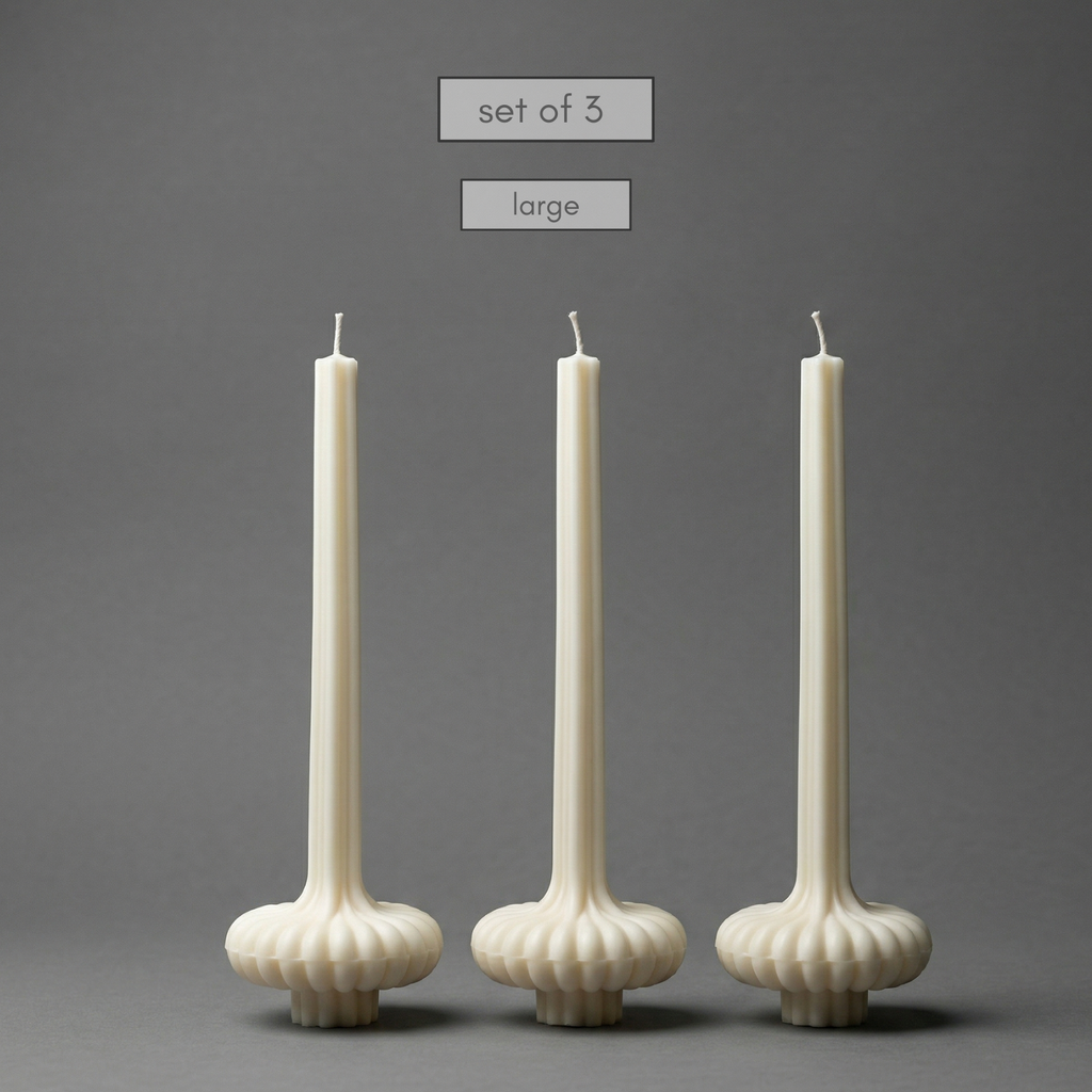 Set of three large white candles with textured holders on a gray background