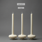 Set of three large white candles with textured holders on a gray background