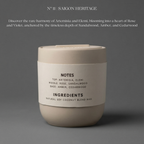 Candle with label on a gray background, featuring ingredients and notes.