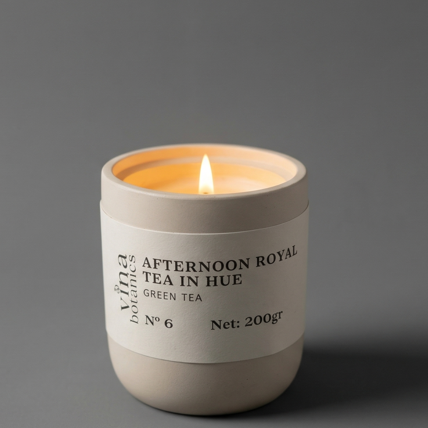 Candle in a white container labeled 'Afternoon Royal Tea in Hue' on a gray background
