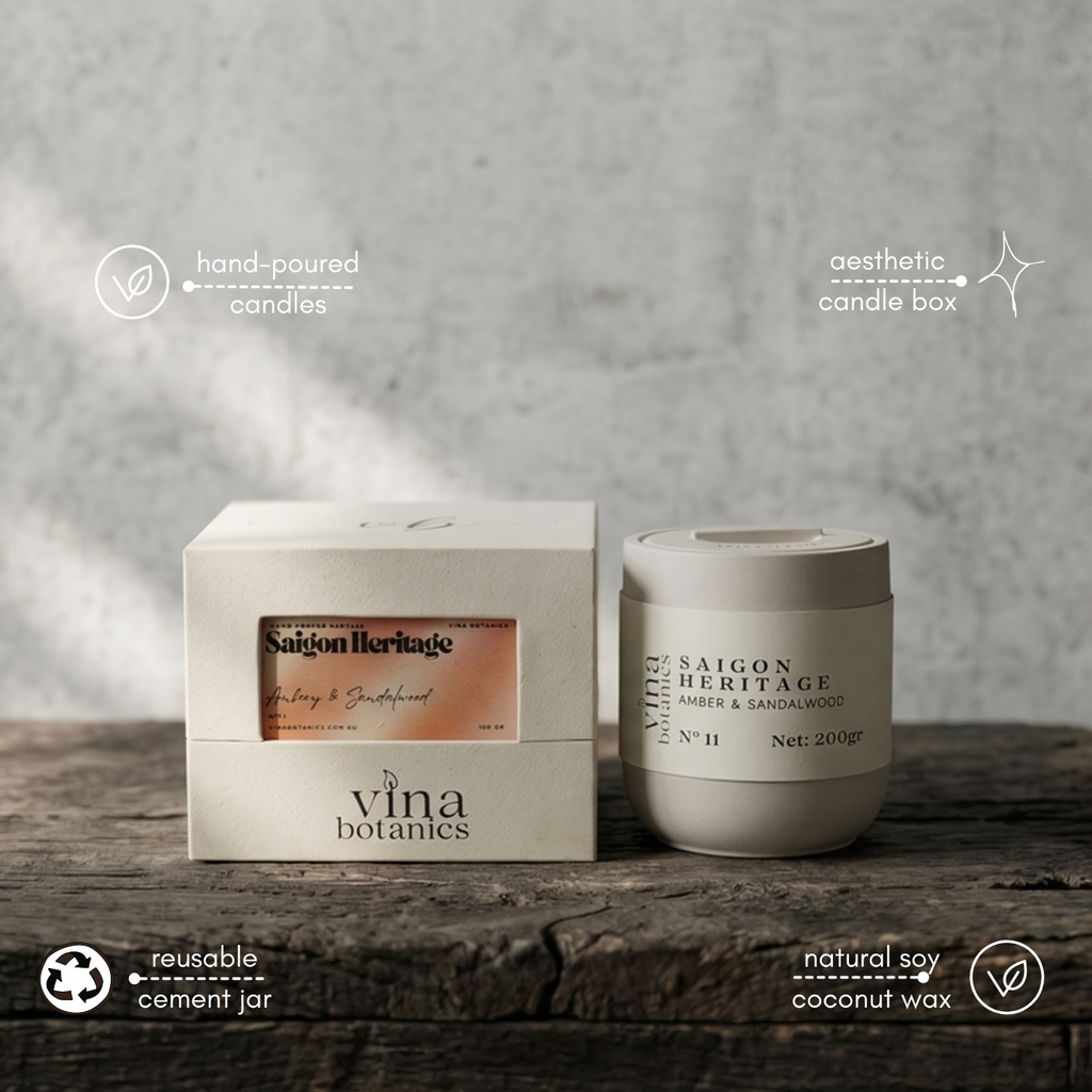 Saigon Heritage candle by Vina Botanics on a wooden surface with a gray background