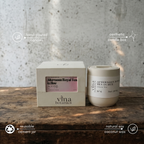 Vina Botanics candle and packaging on a wooden surface with a textured wall background